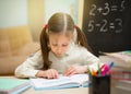 Little student. Beautiful young girl is teaching at home on blackboard. Preschool home education. Royalty Free Stock Photo