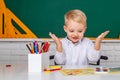 Little student boy happy with an excellent mark. Kid is learning in class on background of blackboard. Little children Royalty Free Stock Photo
