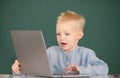 Little student boy using laptop computer in school class. Little funny programmer. Royalty Free Stock Photo