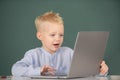 Little student boy using laptop computer in school class. Little funny programmer. Royalty Free Stock Photo
