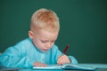 Little student child studying in classroom at elementary school. Kid writing in class. Early education. Royalty Free Stock Photo