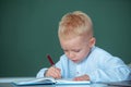 Little student child studying in classroom at elementary school. Kid writing in class. Early education. Royalty Free Stock Photo