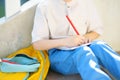 Little student doing homework on break on stair of elementary school building. Back to school concept. Education for kids Royalty Free Stock Photo