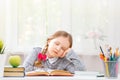 Little student girl sitting at the table, fell asleep at the books. Blurred background. The concept of education and school Royalty Free Stock Photo