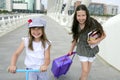 Little student girls going to school in city