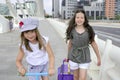 Little student girls going to school in city