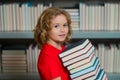 Little student read book. Kid reads books in the library. Schoolboy with book in school library. Literature for reading Royalty Free Stock Photo