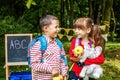 Little students talk and laugh. Children with backpacks and apples. The concept is back to school.