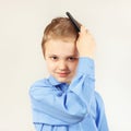 Little stylish boy in bright shirt brushing his hair a hairbrush Royalty Free Stock Photo