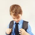 Little stylish boy dresses his suit jacket