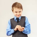 Little stylish gentleman fastened the buttons on sleeve blue shirt