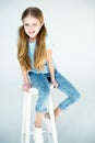 Little stylish grimace girl sitting on chair