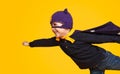 Little superhero flying on yellow background Royalty Free Stock Photo