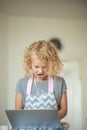 Little suprised astonished girl with laptop in the room