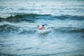 Little surfer learn to ride on surfboard on sea wave. Father with son play in summer ocean, learning surfing. Little boy swim on Royalty Free Stock Photo