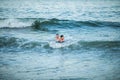 Little surfer learn to ride on surfboard on sea wave. Father with son play in summer ocean, learning surfing. Little boy swim on Royalty Free Stock Photo