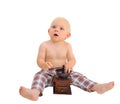 Little surprised baby boy with coffee grinder wearing plaid pants