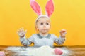 Little surprised Easter girl shows her hands in flour