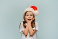 Little surprised girl in santa hat says wow and looks at the camera. Christmas sales Royalty Free Stock Photo