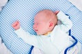 Little swaddled baby in white bed