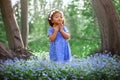 A little swarthy girl among the blue flowers in the park Royalty Free Stock Photo