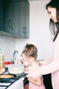 Little sweet girl and her mother fry pancakes at the traditional Russian holiday  Carnival Maslenitsa Shrovetide Royalty Free Stock Photo