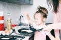 Little sweet girl and her mother fry pancakes at the traditional Russian holiday  Carnival Maslenitsa Shrovetide Royalty Free Stock Photo