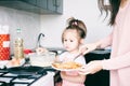 Little sweet girl and her mother fry pancakes at the traditional Russian holiday  Carnival Maslenitsa Shrovetide Royalty Free Stock Photo