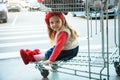 A little sweet girl is sitting in a supermarket shopping cart. Royalty Free Stock Photo