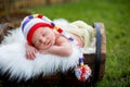 Little sweet newborn baby boy, sleeping in crate with knitted pa Royalty Free Stock Photo