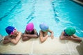 Little swimmers talking while leaning at poolside Royalty Free Stock Photo