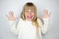 Little tanned girl in white badlon on a gray background.