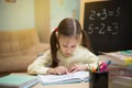 Little teacher. Beautiful young girl is teaching at home on blackboard. Royalty Free Stock Photo