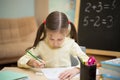 Little teacher. Beautiful young girl is teaching at home on blackboard. Royalty Free Stock Photo