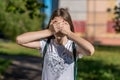 A little teenage girl covered her eyes with her hands. In the summer in the open air. A bright sunny day. The concept of Royalty Free Stock Photo