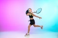 Little tennis girl in black sportwear on gradient background in neon light