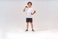 Little tennis player. Full-length shot of a confident teenage boy holding tennis racket and looking at camera isolated