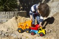 Little boy playing with toy digger and dumper truck. Royalty Free Stock Photo