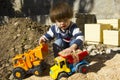 Little boy playing with toy digger and dumper truck. Royalty Free Stock Photo