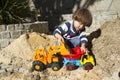 Little boy playing with toy digger and dumper truck. Royalty Free Stock Photo