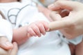 Little tiny baby hand holding mother finger Royalty Free Stock Photo