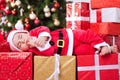 Little tired baby santa sleeping on gifts for christmas Royalty Free Stock Photo