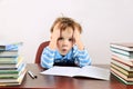 Little tired boy sitting at a desk