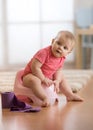 Little toddler baby girl sitting on plastic potty in living room