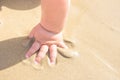 Little Toddler Baby Playing on the Beach at the Sea. Small Hand in Sand. Sunny Summer Day. Vacations Childhood Parenting Charity Royalty Free Stock Photo