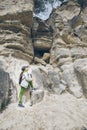 little toddler boy with backpack climbing by rock Royalty Free Stock Photo