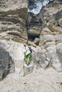 little toddler boy with backpack climbing by rock Royalty Free Stock Photo