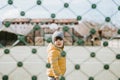 Little toddler boy behind net outdoors, isolated alone during quarantine period at pandemic Royalty Free Stock Photo