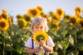 Little toddler boy, child in sunflower field, playing with big flower Royalty Free Stock Photo