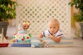 Little toddler boy, dressed as sailor, celebrating his first birthday with sea theme cake, boat, fishes and aqua animals Royalty Free Stock Photo